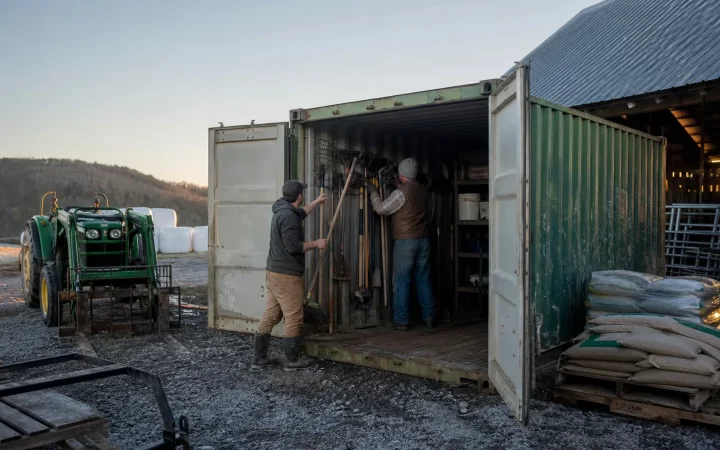 Farm employees using a shipping container for secure equipment storage
