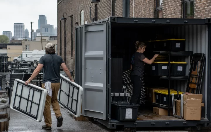 Minneapolis brewery staff organizing seasonal equipment in a steel shipping container